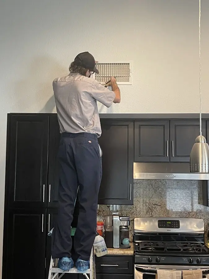 Technician inspecting an air vent during HVAC service in Philadelphia